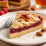 Bakewell-Torte mit Mandeln und Himbeermarmelade, frisch gebacken und dekoriert.