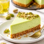 Leckerer Pistazien-Käsekuchen auf einem Teller, dekoriert mit Pistazien.