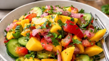 Erfrischender Mangosalat mit Limetten-Dressing auf einem Teller