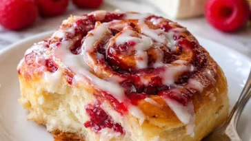 Leckere Himbeer Rollen auf einem Teller serviert.