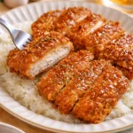 Honig-Knoblauch-Crispy-Hühnchen in einer knusprigen Panade, serviert mit Beilagen.