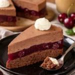 Kirschtorte mit Schokocreme dekoriert mit Kirschen und Schokoladensplittern.