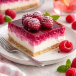 Cremiger Himbeer-Käsekuchen auf einem Teller dekoriert mit frischen Himbeeren