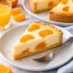 Saftiger Mandarinenkuchen mit frischen Mandarinenstücken dekoriert.
