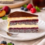 Delikate Mohntorte mit Waldbeeren und Vanillepudding auf einem Teller