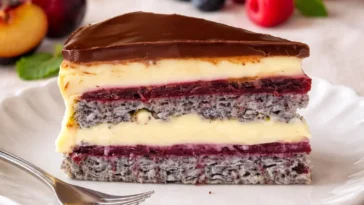 Delikate Mohntorte mit Waldbeeren und Vanillepudding auf einem Teller