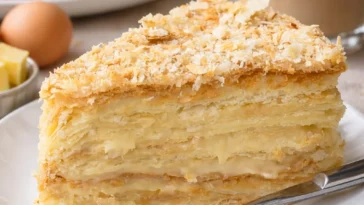 Ein Stück Russischer Napoleon Kuchen auf einem Teller mit dekorativen Elementen.