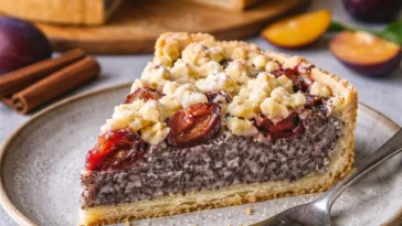 Saftiger Zwetschgen Mohnkuchen mit Pudding und Streuseln auf einem Teller