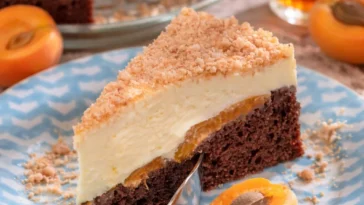 Sägespänetorte mit Aprikosen auf einem Teller serviert.