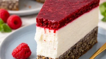 Schneewittchen Torte mit Himbeer, Mohn und Topfen auf einem dekorativen Teller