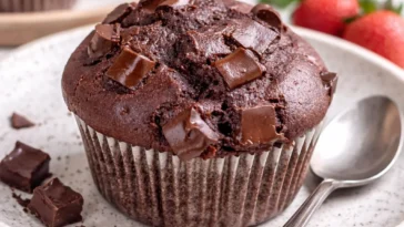 Schoko Muffins auf einem Teller, garniert mit Schokoladensplittern