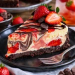Schokoladen-Käsekuchen mit frischen Erdbeeren auf einem Teller.
