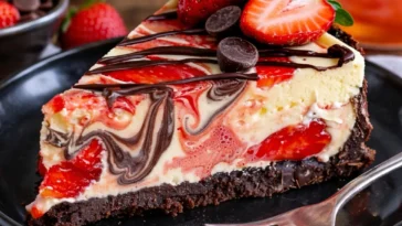 Schokoladen-Käsekuchen mit frischen Erdbeeren auf einem Teller.