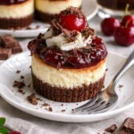 Schwarzwälder Mini-Käsekuchen mit Kirschen und Schokolade auf einem Teller