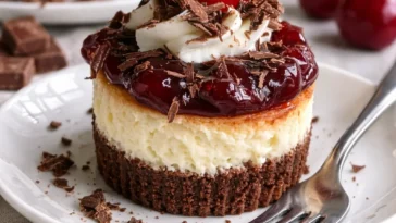 Schwarzwälder Mini-Käsekuchen mit Kirschen und Schokolade auf einem Teller