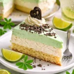 Waldmeistertorte mit frischem Waldmeister und Sahne, auf einem Teller serviert.
