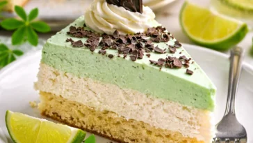 Waldmeistertorte mit frischem Waldmeister und Sahne, auf einem Teller serviert.