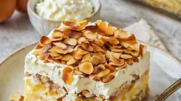Bienenstich-Tiramisu auf einem Teller mit Mandeln und Karamell-Dekoration.