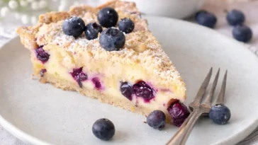 Blaubeer-Tarte mit Vanille-Schmand und Streuseln auf einem Teller