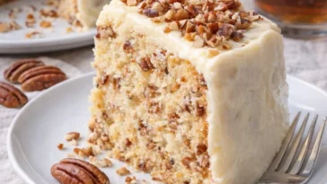 Butter-Pecan-Kuchen mit Nüssen und Karamellsoße auf einem Teller