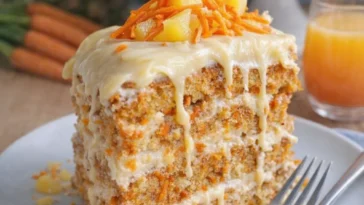 Karottenkuchen mit Frischkäse-Glasur auf einem Teller serviert.