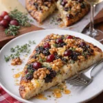 Fladenbrot mit Brie und Cranberries, serviert auf einem Holzbrett.
