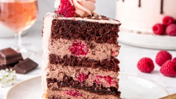 Himbeer-Törtchen mit frischen Himbeeren und Sahne in einer eleganten Präsentation.