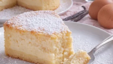 Magischer Vanillepuddingkuchen auf einem Teller, garnierte mit frischen Beeren.