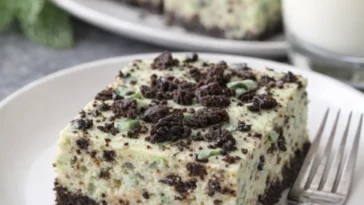 Minz-Oreo-Cheesecake-Riegel auf einem Teller, dekoriert mit Minzblättern