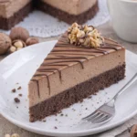 Nuss-Nougat-Torte mit Schokoboden auf einem Teller angerichtet