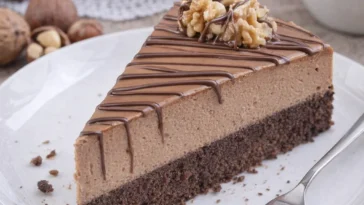 Nuss-Nougat-Torte mit Schokoboden auf einem Teller angerichtet