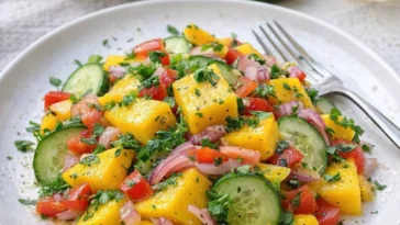 Erfrischender Mango-Salat mit Limetten-Dressing auf einem Teller