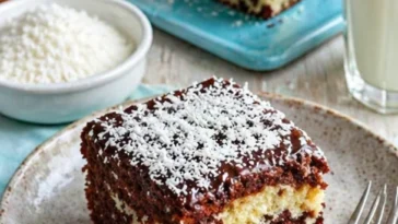 Saftiger Bounty Kuchen vom Blech mit Kokos und Schokolade dekoriert