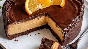Schokoladen-Orange-Cheesecake-Layer-Kuchen auf einem Teller serviert