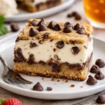 Schokoladenkekskäsekuchen mit Schokoladenglasur und Kekskrümeln dekoriert.