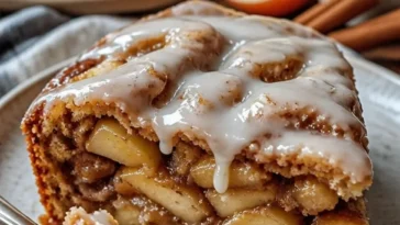 Apfel-Zimtschnecken-Kuchen mit Zimt und Äpfeln auf einem Teller serviert