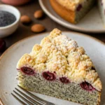 Joghurt-Mohn-Kuchen mit Kirschen und Streuseln auf einem Tisch serviert