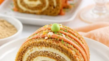 Saftige Karottenkuchenrolle mit cremiger Füllung auf einem Teller