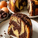 Klassischer Mamorkuchen auf einem Teller, dekoriert mit Puderzucker