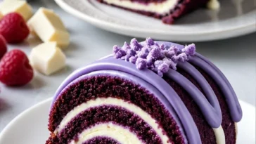 Lila Samt-Kuchenrolle auf einem eleganten Teller mit Dekoration.