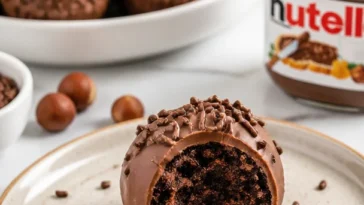 Schokoladige Nutella-Trüffel auf einem Teller, verziert mit Kakaopulver
