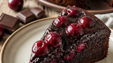 Schokoladen-Kirsch-Kuchen mit Karamell-Topping auf einem Teller serviert