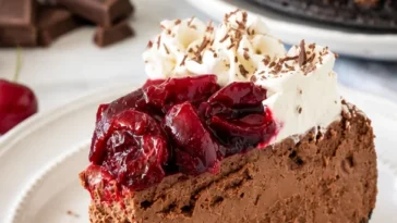 Schwarzwälder Käsekuchen mit Schokoladenglasur und Kirschen dekoriert