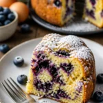 Sommerkuchen mit Blaubeeren und Buttermilch auf einem Teller serviert