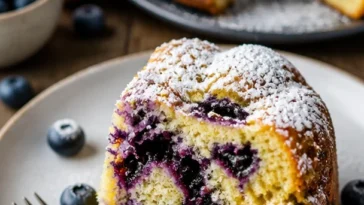 Sommerkuchen mit Blaubeeren und Buttermilch auf einem Teller serviert