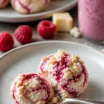 Himbeer-Frischkäse-Bites auf einem Teller dekoriert mit frischen Himbeeren