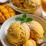 Hausgemachtes Mango-Kokos-Eis in einer Schale mit tropischen Früchten