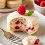 Himbeer-Macarons auf einem eleganten Teller, dekoriert mit frischen Himbeeren.
