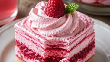 Himbeermousse mit frischen Himbeeren und Sahne in einem eleganten Dessertglas