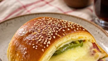 Leckere Käse-Pfefferoni-Brötchen frisch gebacken auf einem Holzbrett